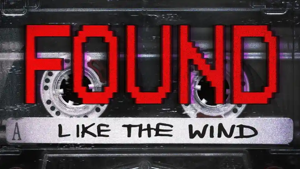 A vintage cassette tape with a glitchy, pixelated red 'FOUND' text overlaid across the top, and 'LIKE THE WIND' written in…