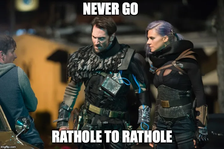 A still from a sci-fi movie shows two armored characters, one male and one female, standing with stern expressions while…