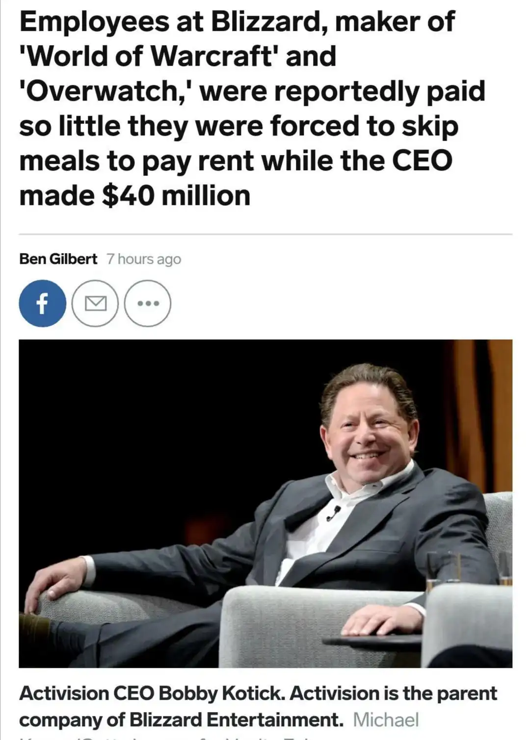 The image shows a smiling man in a suit sitting in a chair, overlaid with text reporting that Blizzard employees were paid…