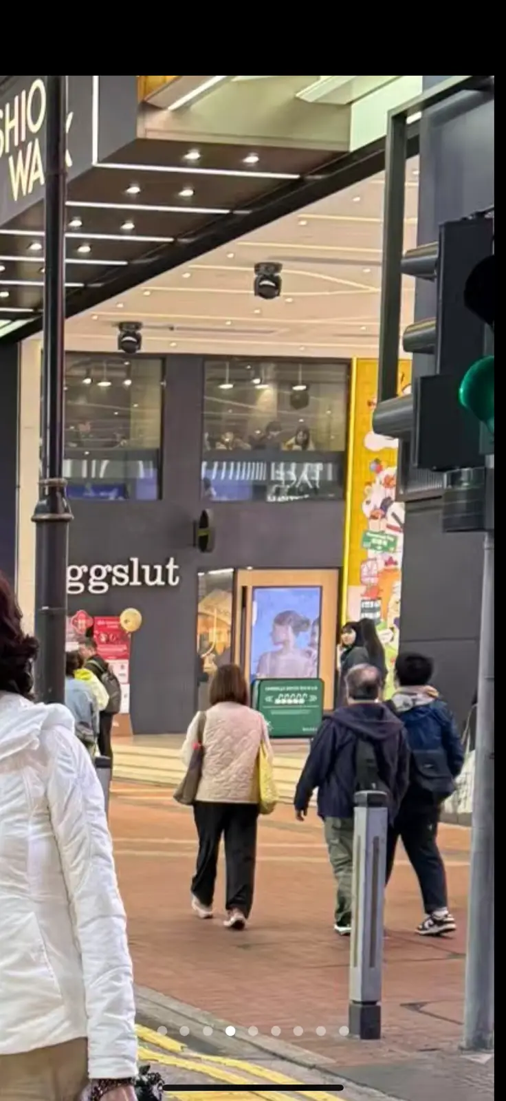 A street-level photo shows pedestrians walking past a storefront with the word 'eggslut' visible on its facade. Above the…