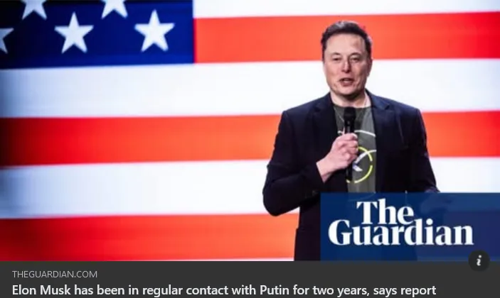 A man, identified as Elon Musk, stands at a podium holding a microphone, in front of a large American flag backdrop. The…