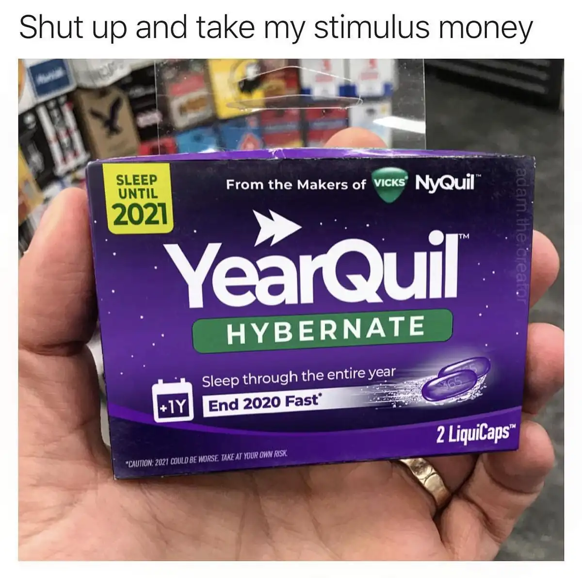 A hand holds a purple box of 'YearQuil HYBERNATE' sleep aid, a parody of NyQuil, with text claiming to 'Sleep until 2021'…