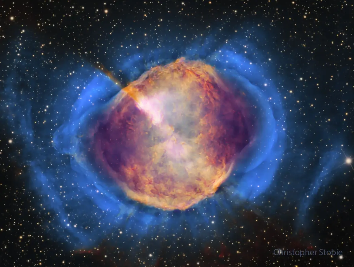 A cosmic nebula with a glowing orange and purple central region surrounded by blue gas clouds against a starfield, overlaid…