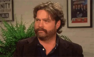 A six-panel image shows actor Zach Galifianakis in a dark blazer over a blue shirt, seated in front of a green fern and…