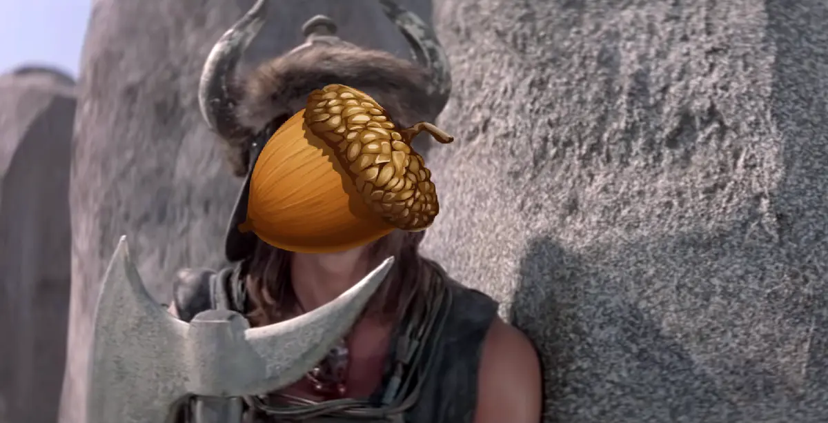 A person wearing a horned helmet and holding an axe has an acorn digitally placed over their face, obscuring their features…