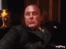 A six-panel sequence shows a man in a dark suit reacting with escalating disbelief and shock, starting with a calm…