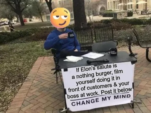 A person with a face obscured by a yellow emoji sits at a small outdoor table with a sign that reads 'If Elon's salute is a…