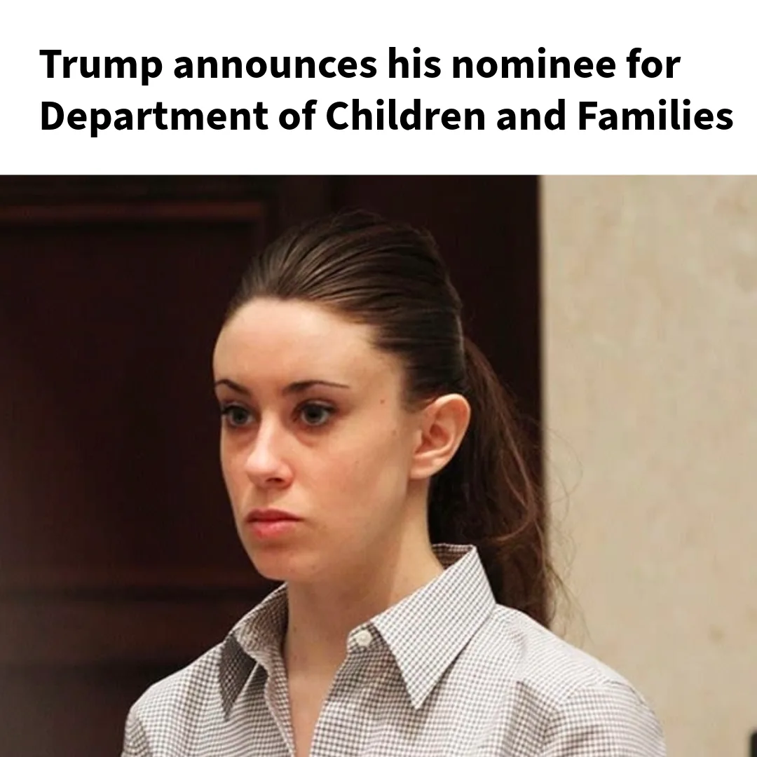 A woman with dark hair in a ponytail, wearing a checkered button-up shirt, stares blankly with a neutral, unimpressed…