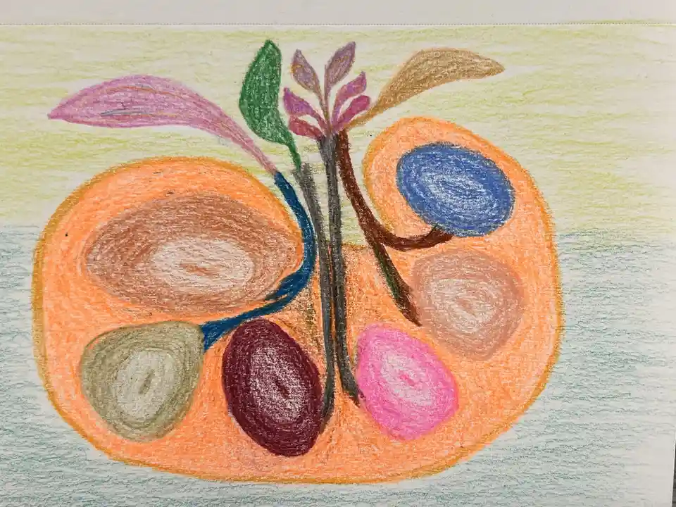 A child's crayon drawing depicts a stylized orange-colored object resembling a fruit or abstract shape with multiple colored…