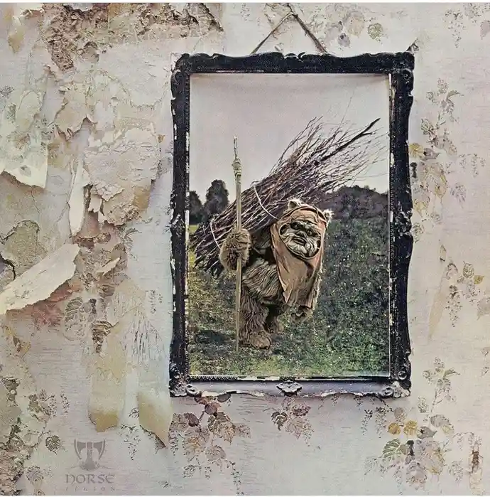 A framed photograph of an Ewok from Star Wars, holding a spear and carrying a bundle of sticks, hangs on a wall with peeling…