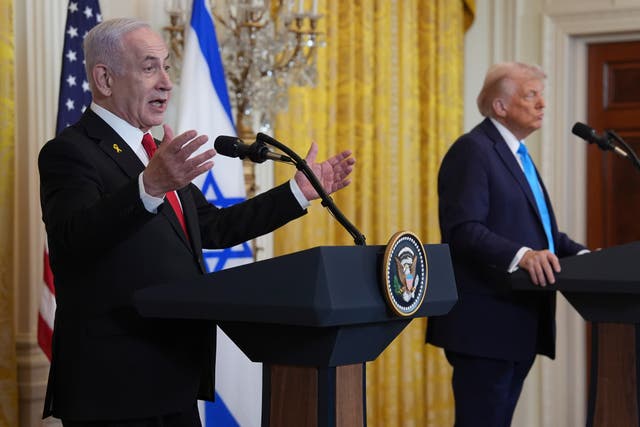 A photo shows Israeli Prime Minister Benjamin Netanyahu speaking animatedly at a podium bearing the Seal of the President of…