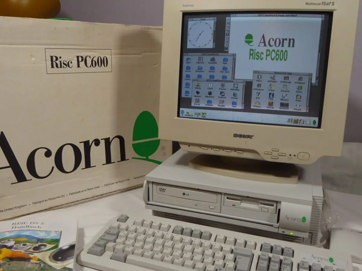 An Acorn Risc PC600 computer with a beige Sony Trinitron monitor displaying the Risc OS 3 desktop, sitting on top of its…