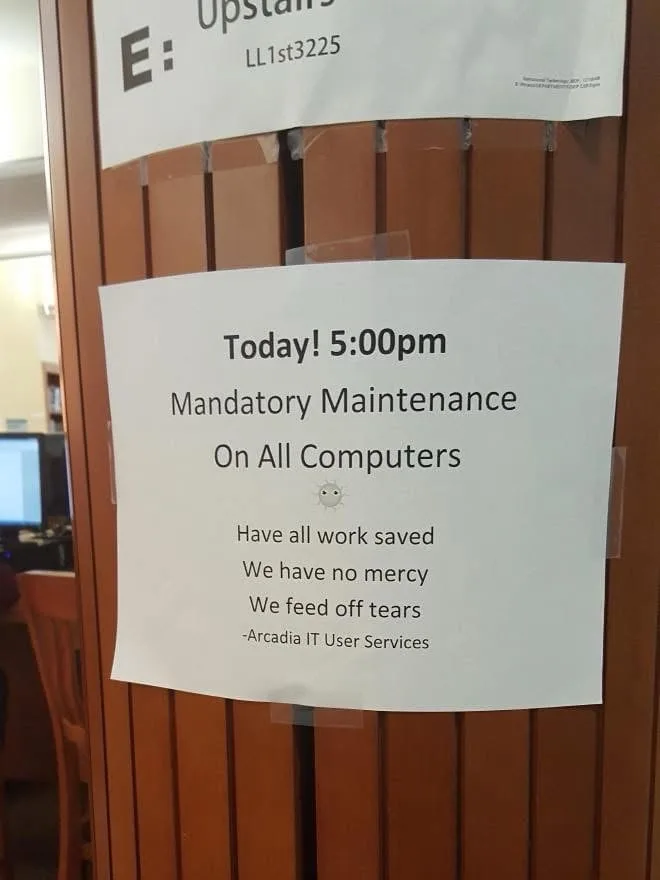 A white paper sign taped to a wooden door announces 'Today! 5:00pm Mandatory Maintenance On All Computers' followed by the…