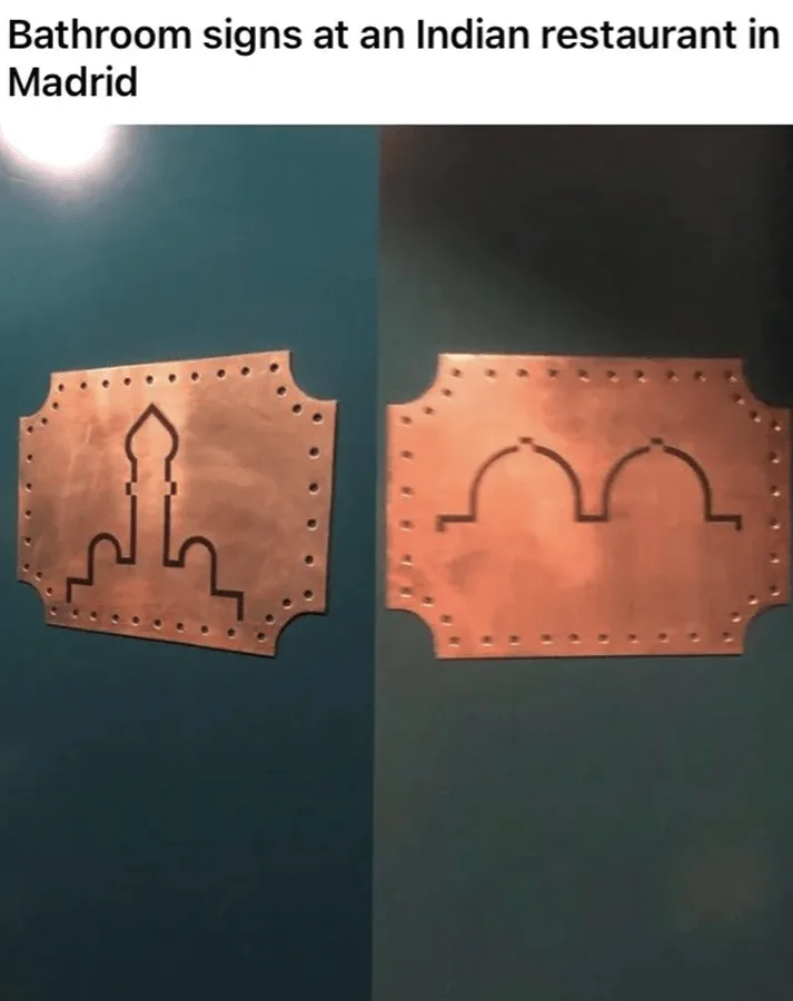 Two copper-colored, riveted metal signs on dark teal walls, one shaped like a mosque minaret and the other like a pair of…
