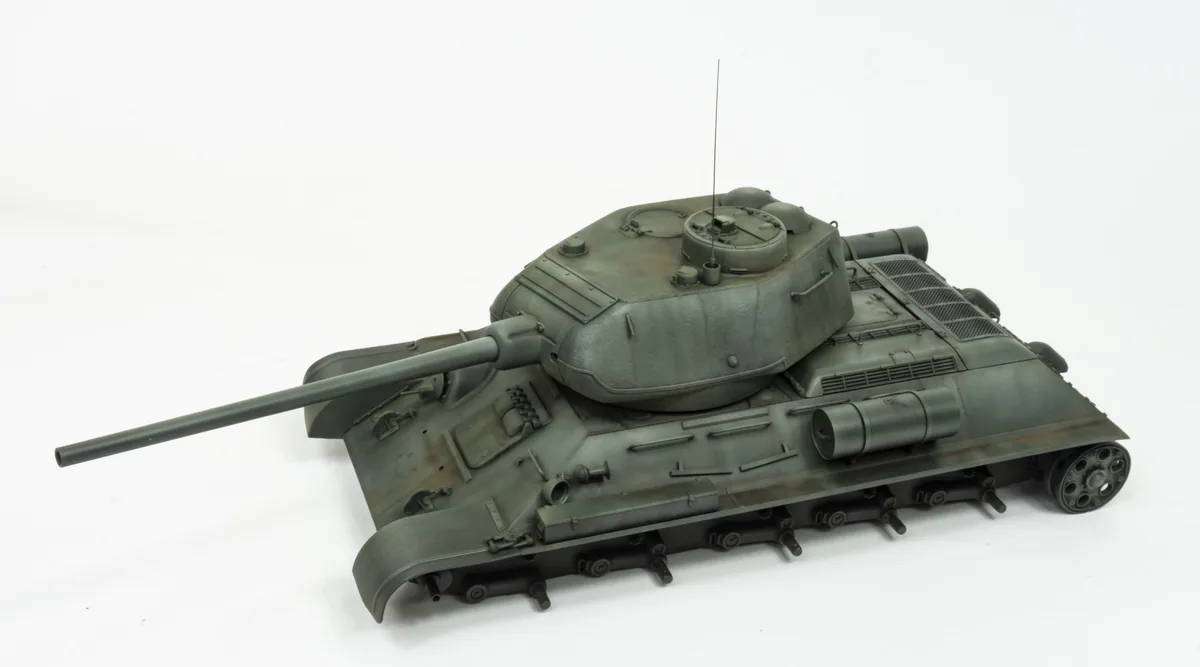 A detailed green model of a military tank with a long barrel, treads, and a turret, photographed against a plain white…