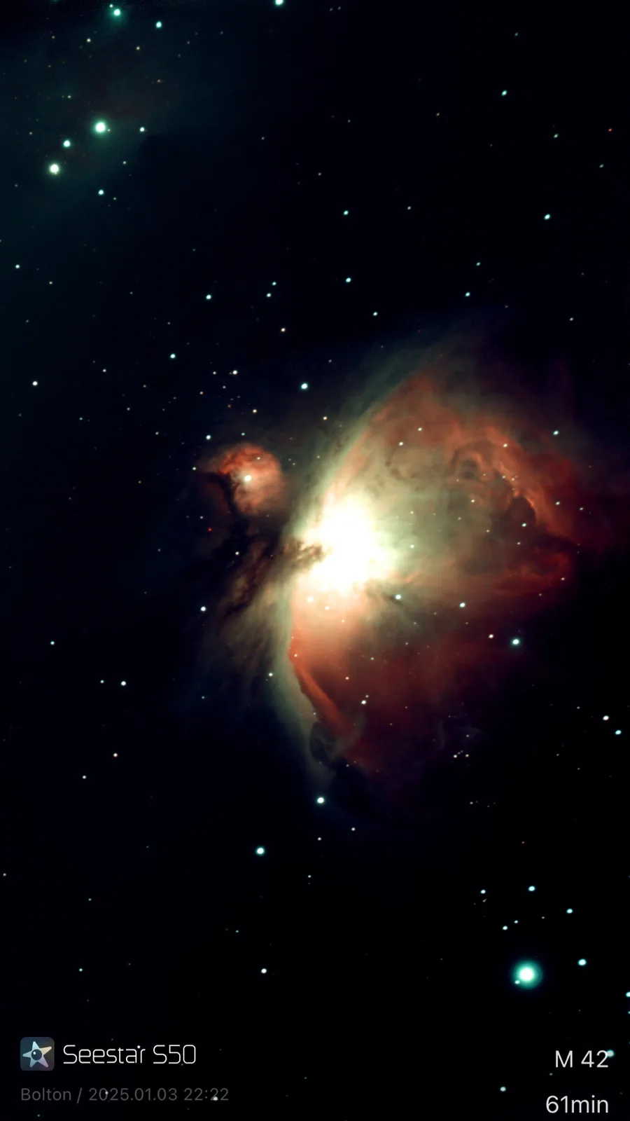 A deep-sky astrophotograph of the Orion Nebula (M42), showing glowing red and orange gas clouds illuminated by bright stars…
