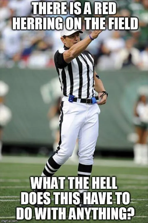 A football referee in a black-and-white striped shirt and white pants stands on a green field, pointing his right arm upward…
