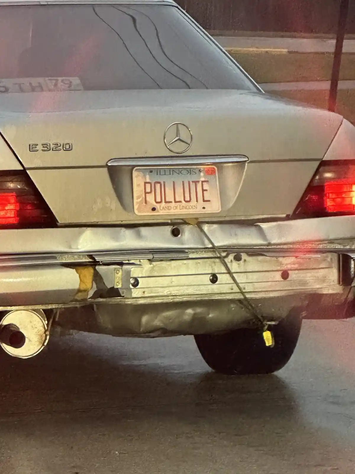 The rear of a silver Mercedes-Benz E320 is shown, featuring an Illinois license plate with the word 'POLLUTE' in large red…