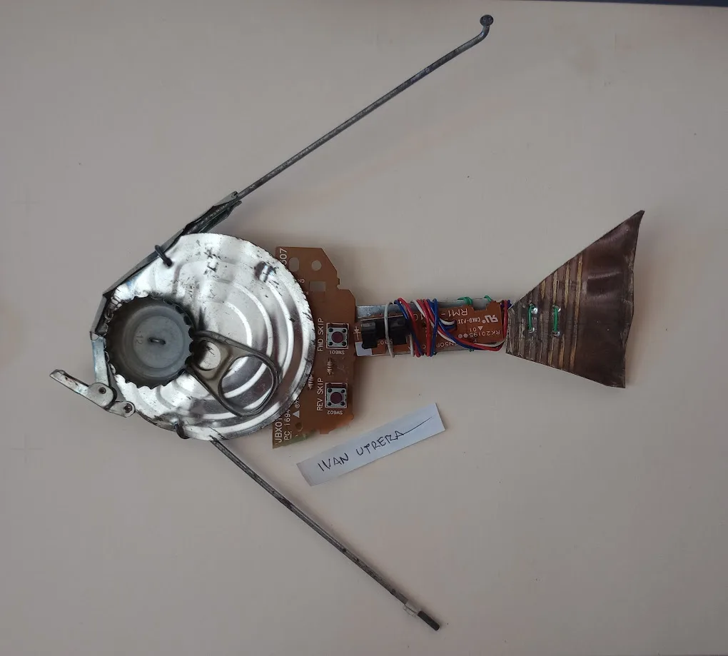 A handmade fish sculpture crafted from electronic components and metal parts, including a circuit board, wires, a bottle…