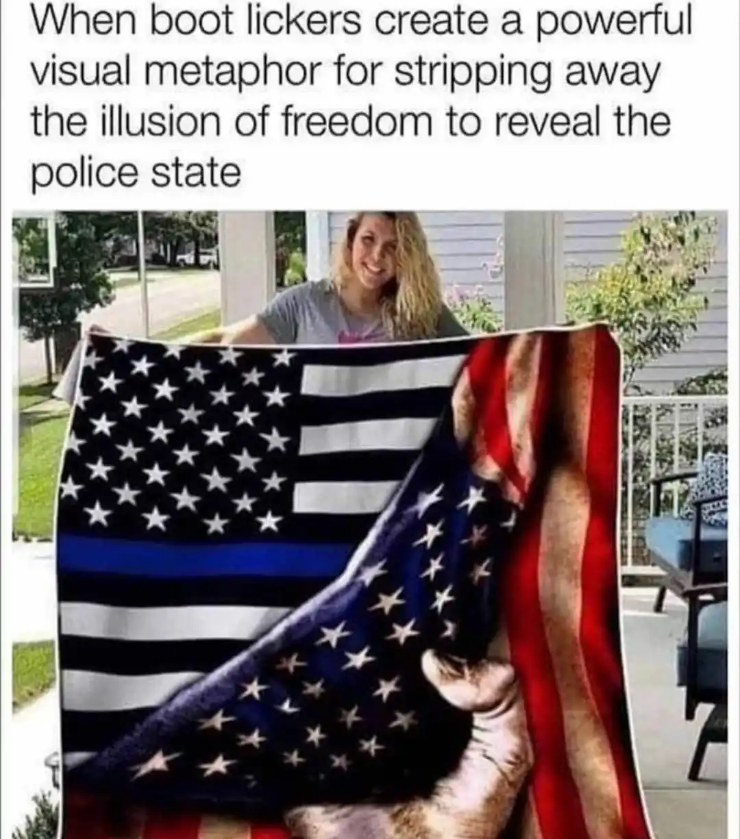 A woman holds up a large American flag blanket that has been partially peeled back to reveal a police officer's boot…
