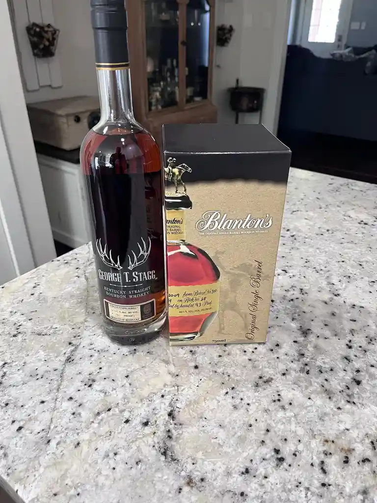 A bottle of George T. Stagg Kentucky Straight Bourbon Whiskey sits next to its Blanton's Original Single Barrel Bourbon…