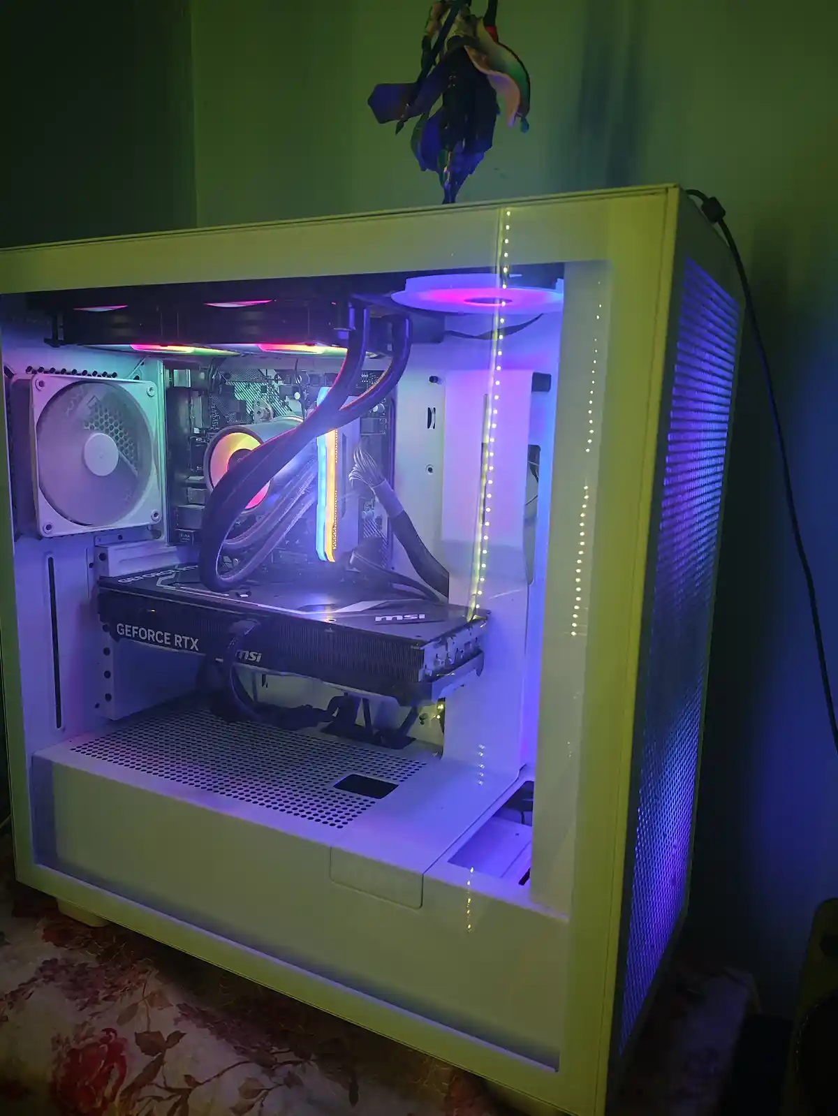A white NZXT computer case with a clear side panel, showcasing internal components like an MSI GeForce RTX graphics card…