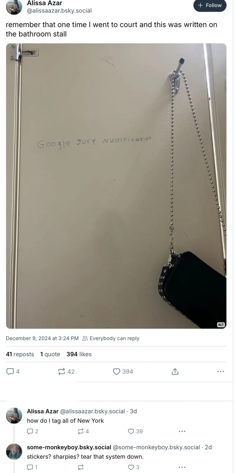 A close-up photo of a beige bathroom stall door with the phrase 'Google JURY NULLIFICATION' written in black marker. A…