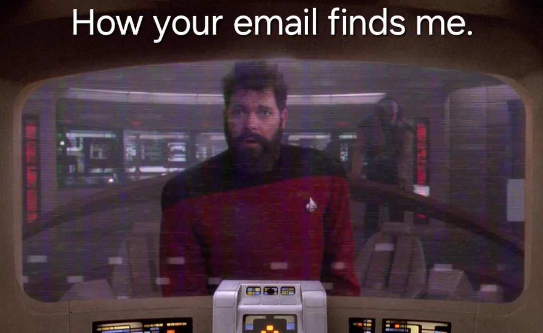 A man with a beard wearing a red Starfleet uniform from Star Trek: The Next Generation is shown on a screen with a glitchy…
