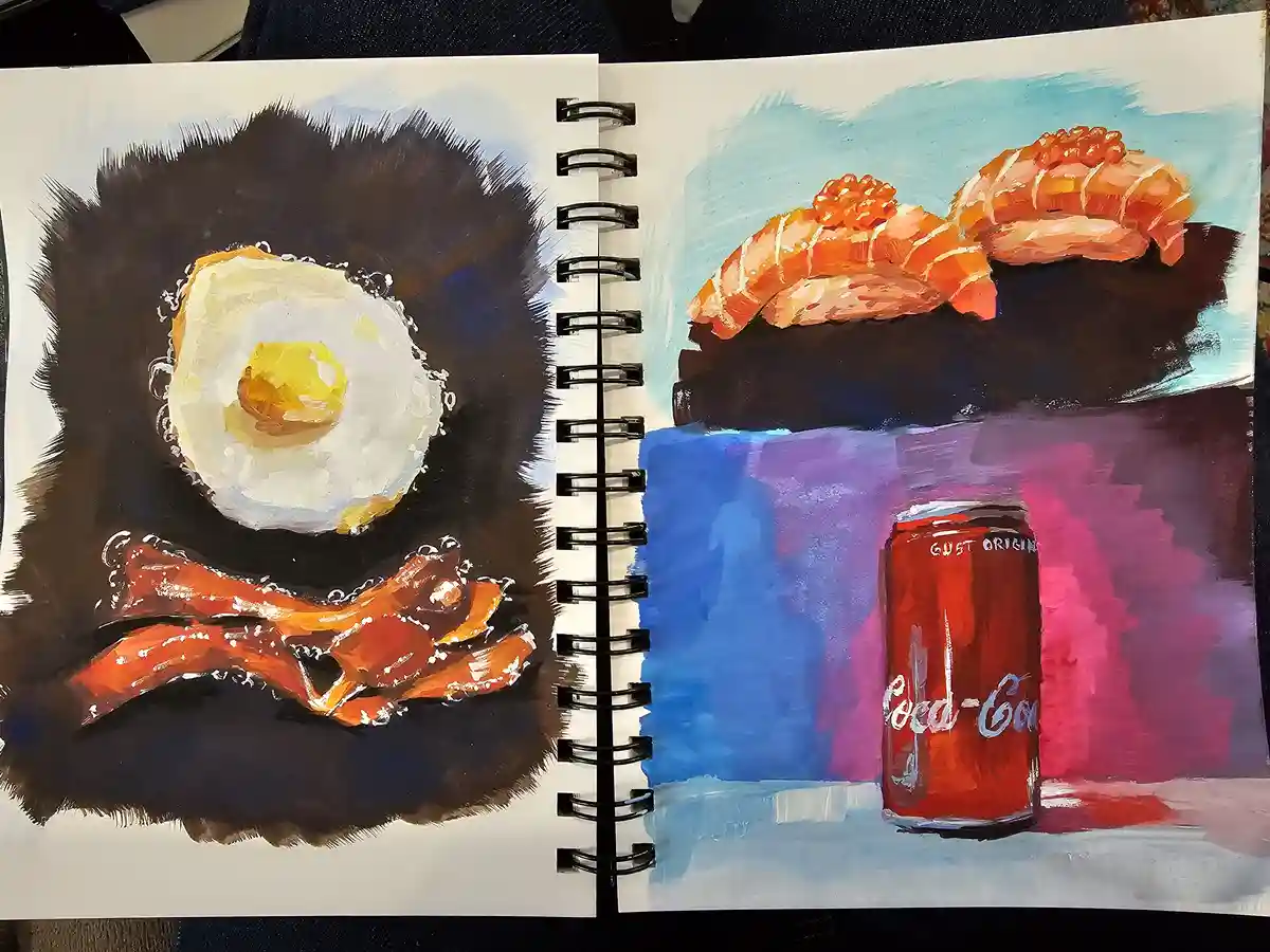 A hand-painted sketchbook spread shows two contrasting meals: left page has a fried egg and bacon against a dark background…