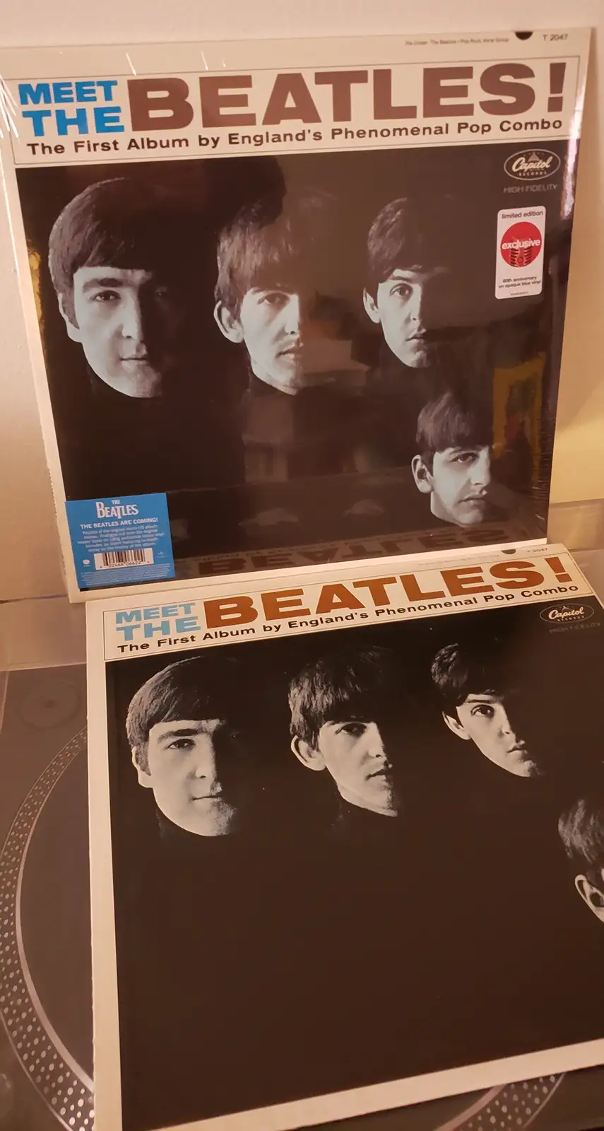 Two copies of The Beatles' 'Meet The Beatles!' album cover are shown, one stacked atop the other. Both feature the iconic…