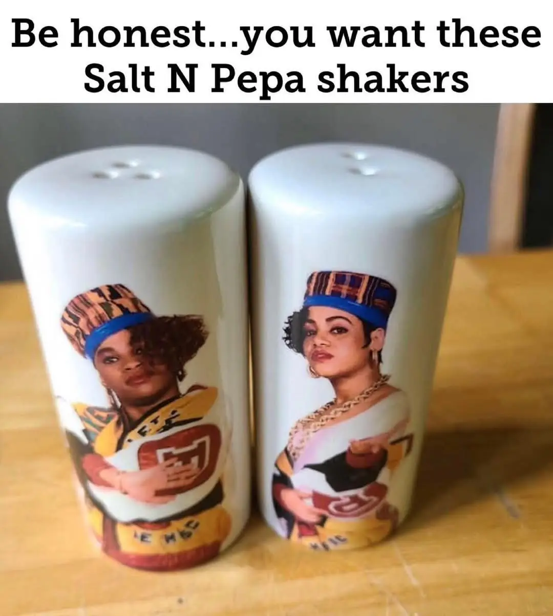 Two white ceramic salt and pepper shakers sit side by side on a wooden surface, each featuring a full-color portrait of a…