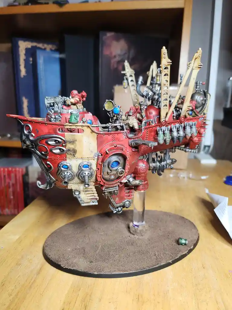 A highly detailed, red and silver painted Warhammer 40k-style miniature vehicle with multiple weapons, crew figures, and…