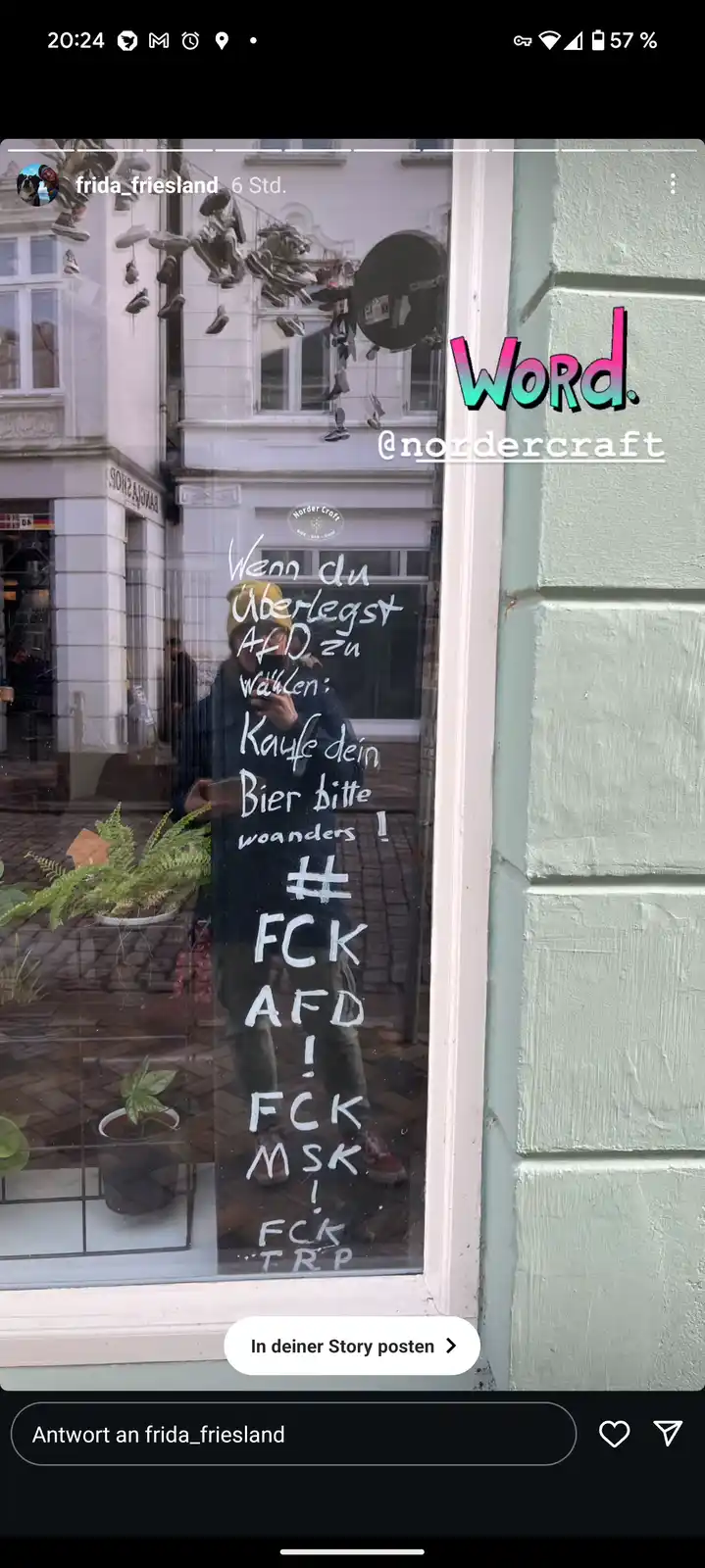 A person's reflection is visible in a shop window, which has white handwritten text in German. The text reads: 'Wenn du…