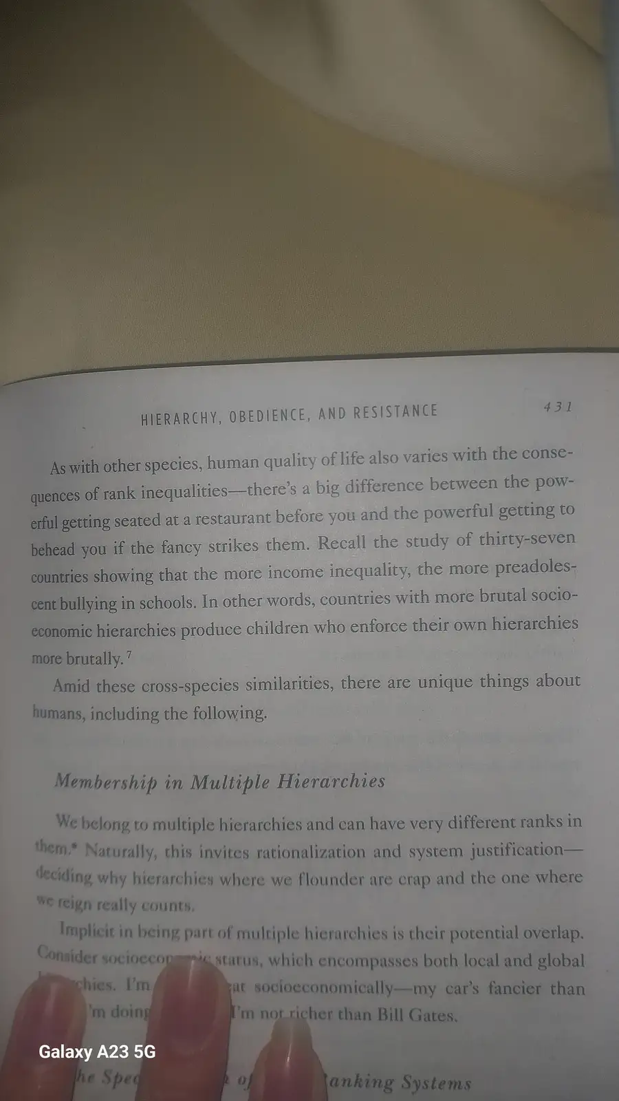 A close-up photo of a book page titled 'Hierarchy, Obedience, and Resistance' with fingers pointing to a sentence that reads…