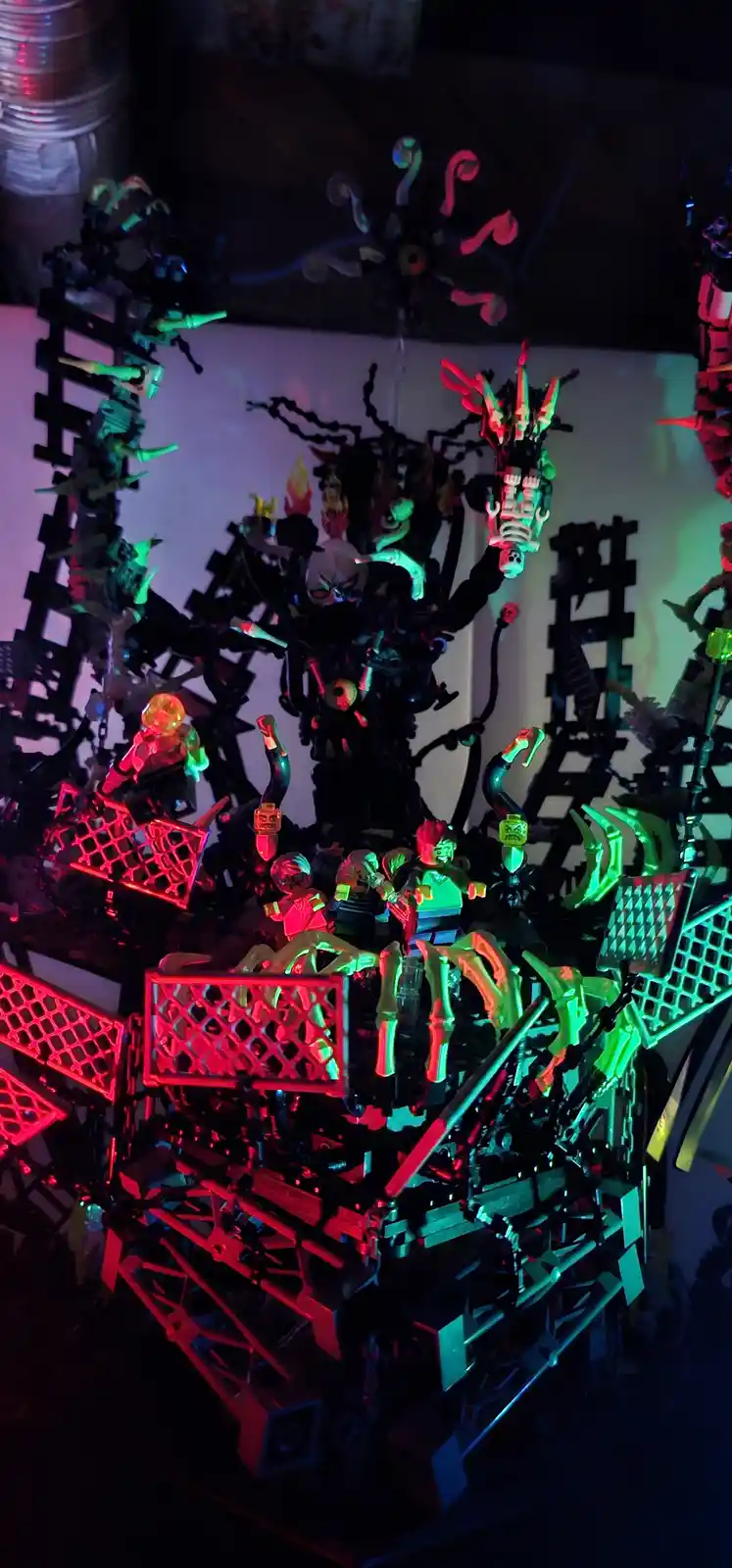 A complex, dark, and elaborate LEGO diorama featuring a central monstrous figure with multiple limbs and glowing red and…