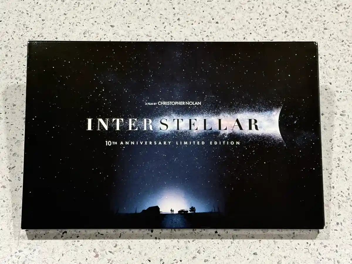A physical copy of the movie 'Interstellar' sits on a speckled countertop. The cover art shows a starry sky with a nebula…