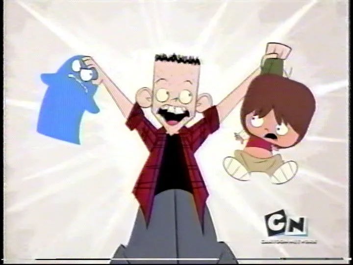 A cartoon boy with spiky hair, wearing a red plaid shirt, stands with arms raised triumphantly, holding a blue ghost and a…