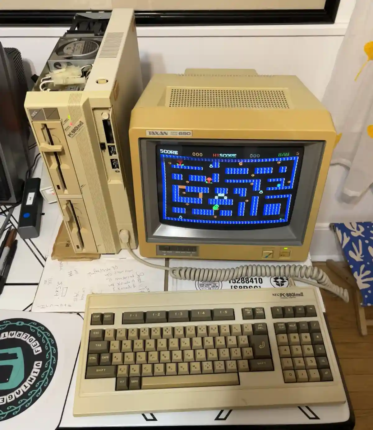 A beige NEC PC-8801mkII personal computer setup with a Taxan Super Vision 650 monitor displaying the classic arcade game…