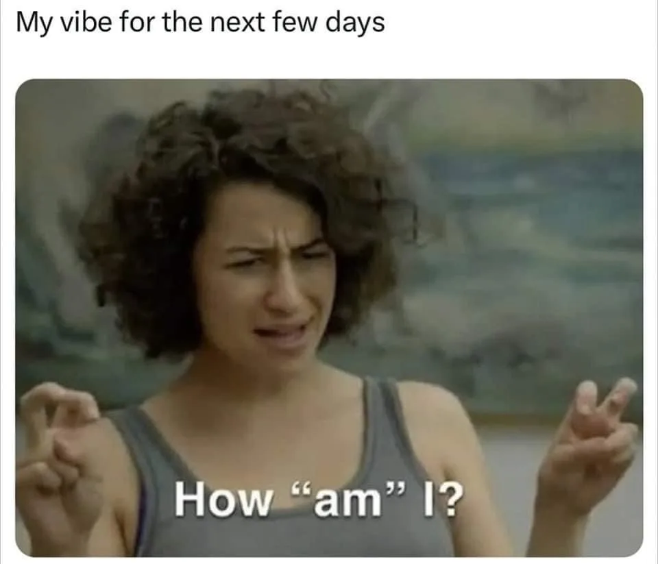 A woman with curly dark hair and a gray tank top makes a confused, frustrated face while holding up both hands with fingers…