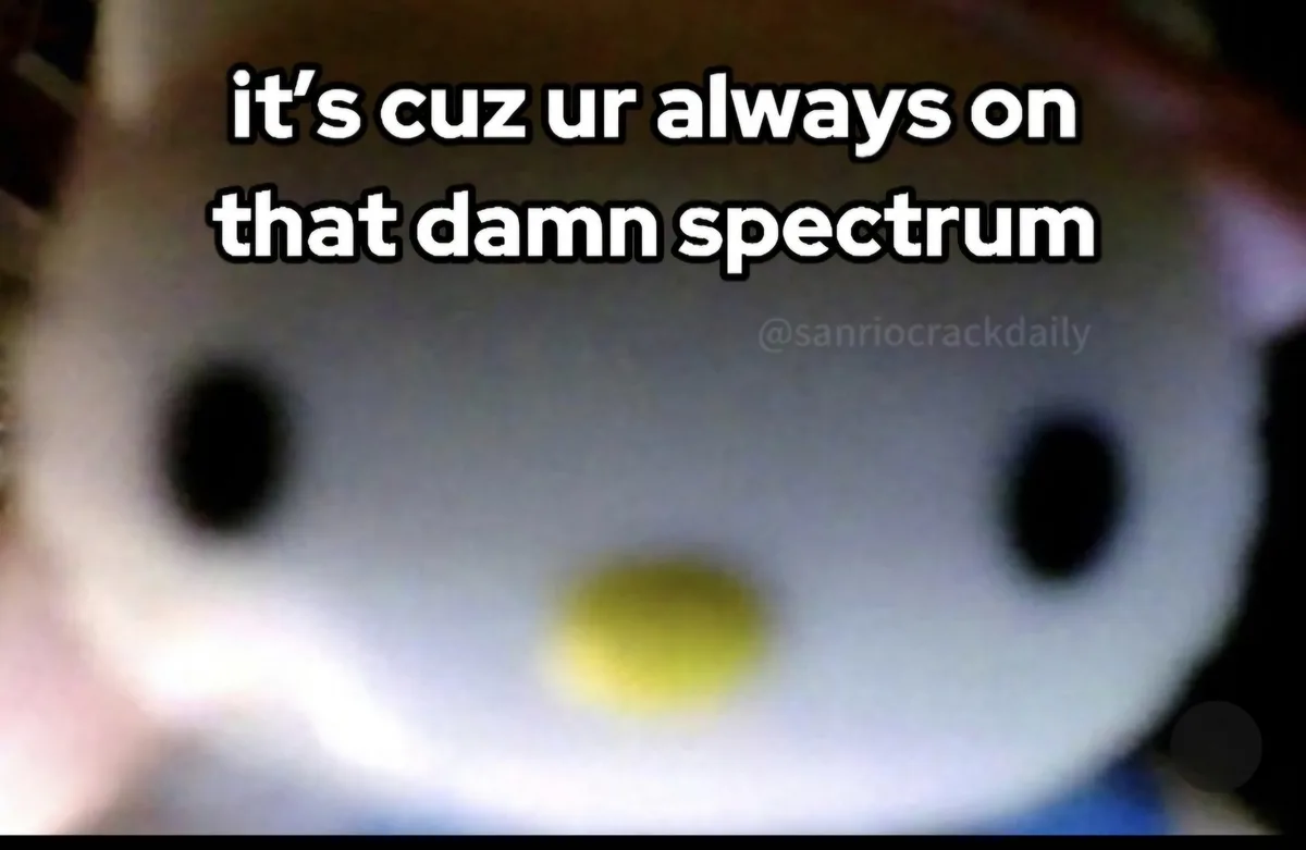 A blurry close-up of a white, round-faced plush toy with black eyes and a yellow beak-like nose, overlaid with bold white…