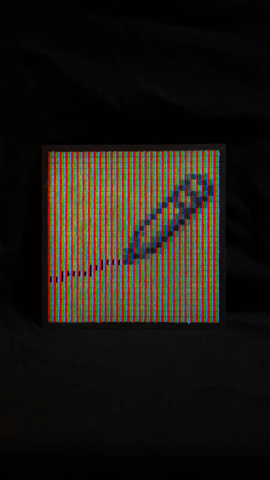 A close-up photo of a camera sensor's pixel array, showing vertical red, green, and blue stripes with a pixelated, blurry…