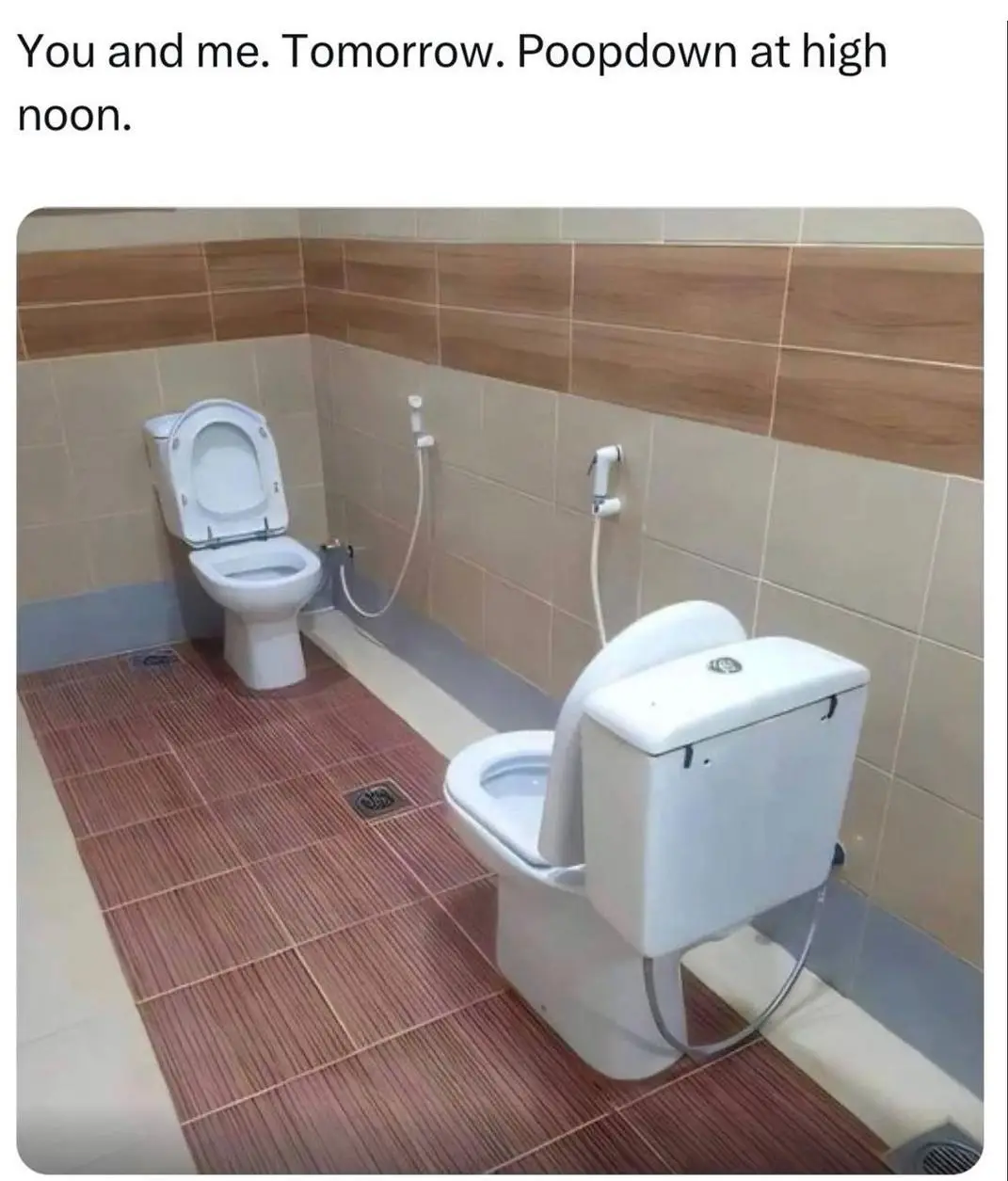 The image shows a bathroom with two toilets side by side, one for sitting and one for standing, both with bidet sprayers…