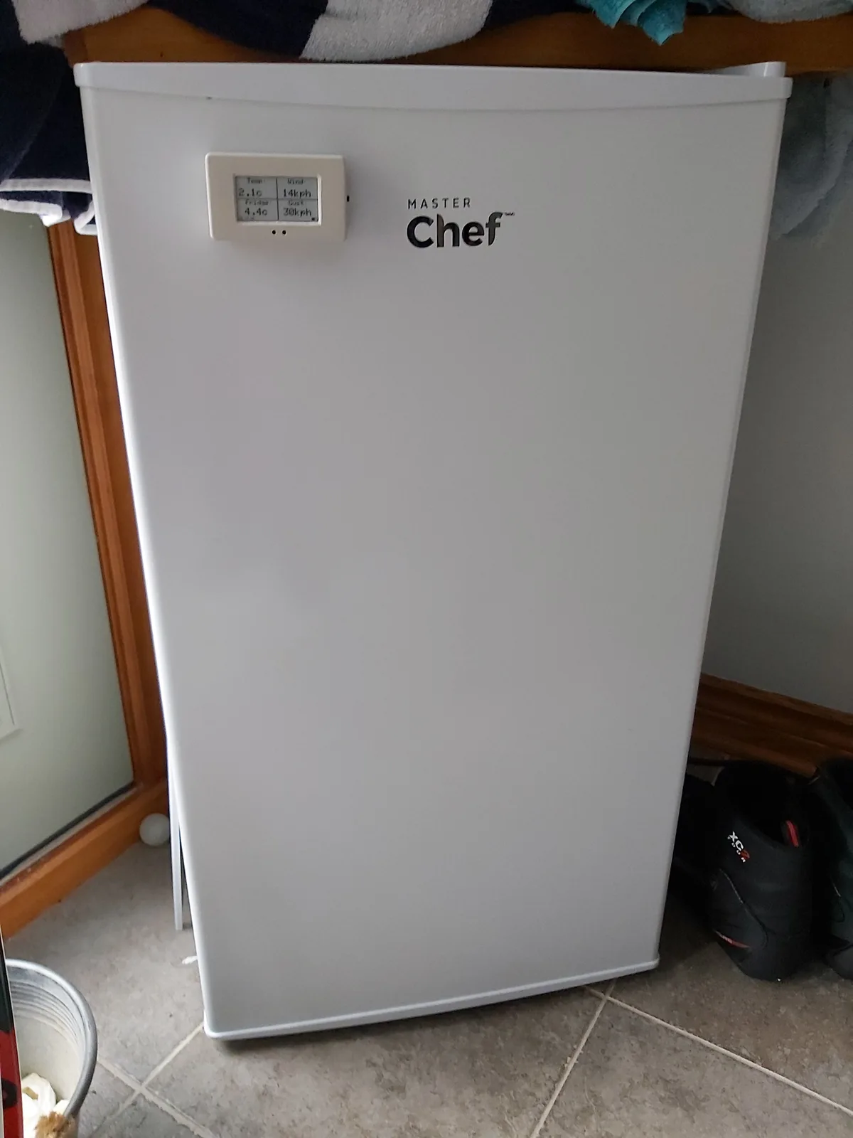 A white, upright mini fridge with 'MASTER Chef' branding on its door, featuring a small digital display showing temperature…