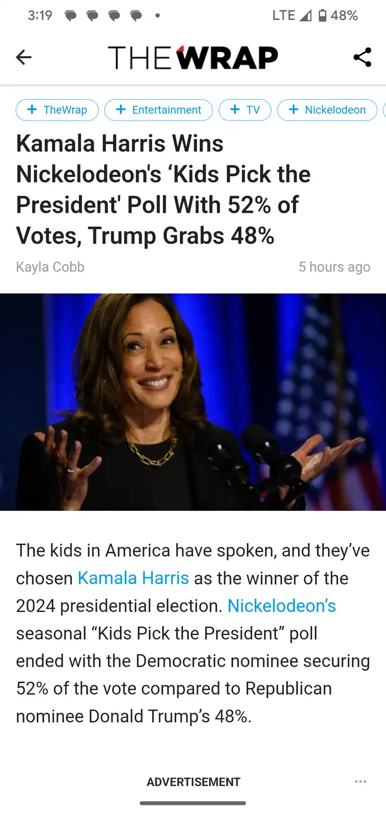 A screenshot of a TheWrap news article shows a smiling Kamala Harris at a podium with an American flag in the background…