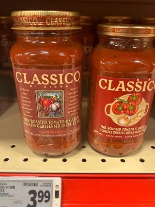 Two jars of Classico pasta sauce sit side-by-side on a store shelf, with a price tag showing $3.99. The labels clearly read…