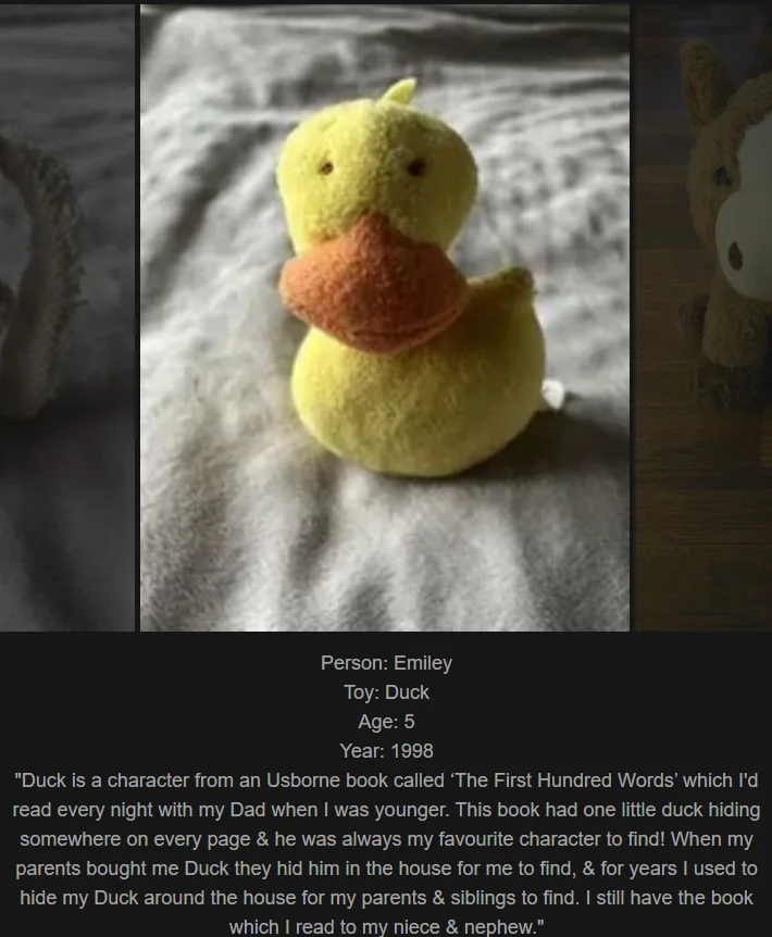 A close-up photo of a small, yellow, fuzzy plush duck toy with an orange beak, sitting on a textured white blanket. The…