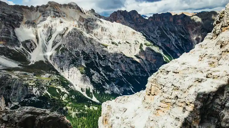 Granite peaks rise like giants, their rugged faces weathered to a warm golden brown, set against a brilliant blue sky with…