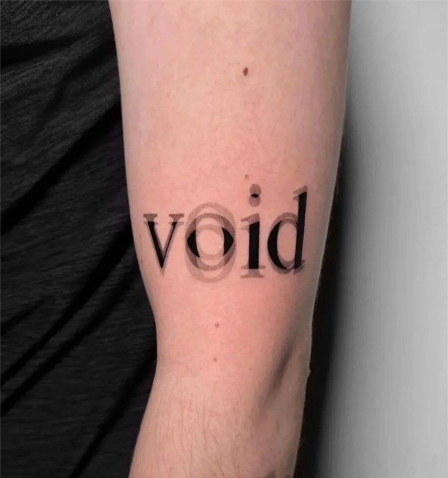 A close-up photo shows a tattoo on a person's forearm, displaying the word 'void' in a simple black font. The letter 'o' is…