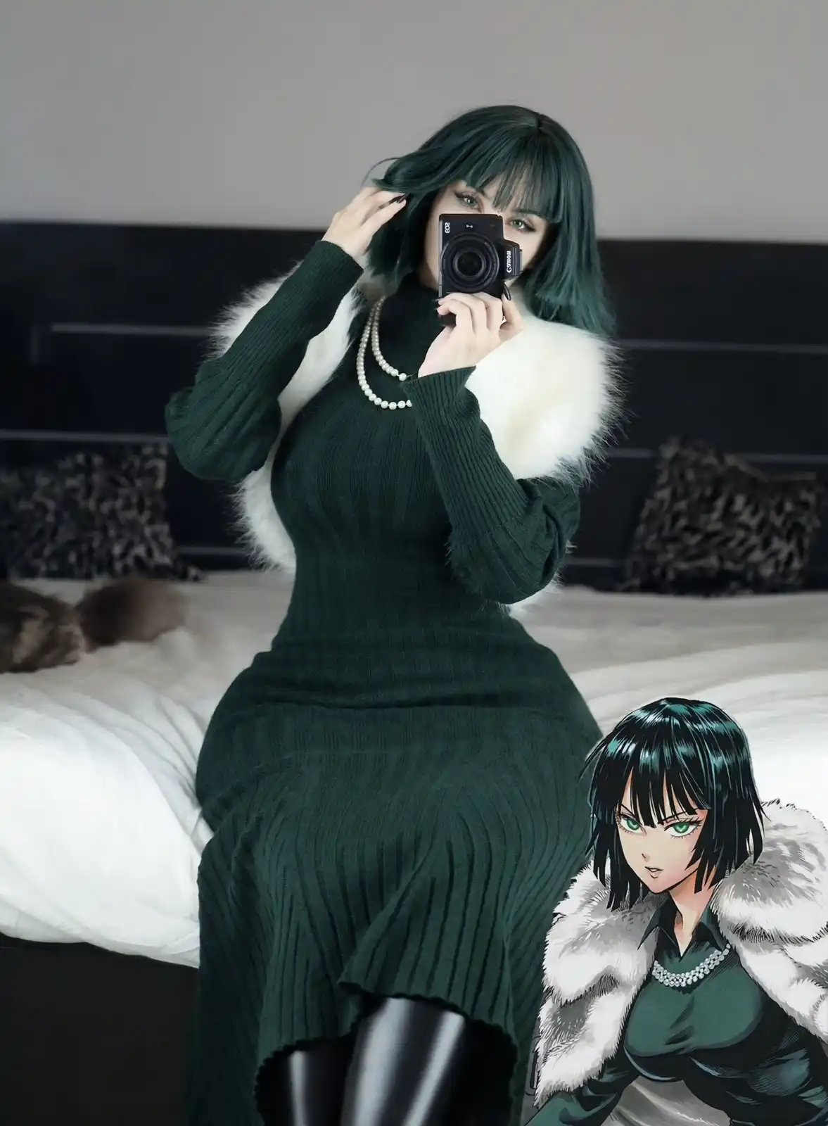 A person with teal hair and green eyes sits on a bed wearing a dark green ribbed dress with a white fur collar and pearl…