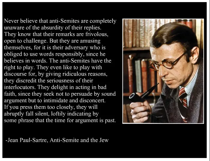 A black-and-white image of Jean-Paul Sartre holding a pipe, looking thoughtful, with a bookshelf behind him. The image is…